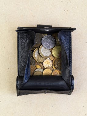 İçinde bozuk para olan bir çanta masanın üzerinde. Hafif bir arkaplanda aç