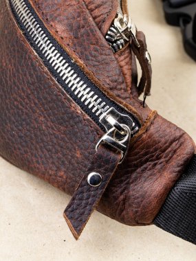 Deri ürünlerdeki elementler: Kemerler, bağlayıcılar, fermuarlar. Işık arkaplanındaki resmi kapat