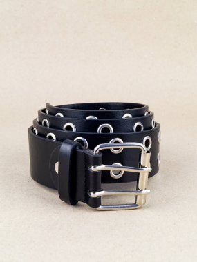 Kopçası düzgün bir şekilde masanın üzerinde duran deri bir kemer. Arkaplan ışığı kağıdı