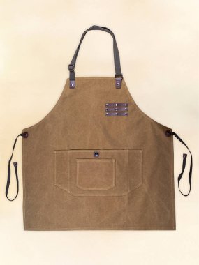 Kumaş desenli önlük ve açık arkaplanda deri elementler. Açılmış bir önlüğün fotoğrafı