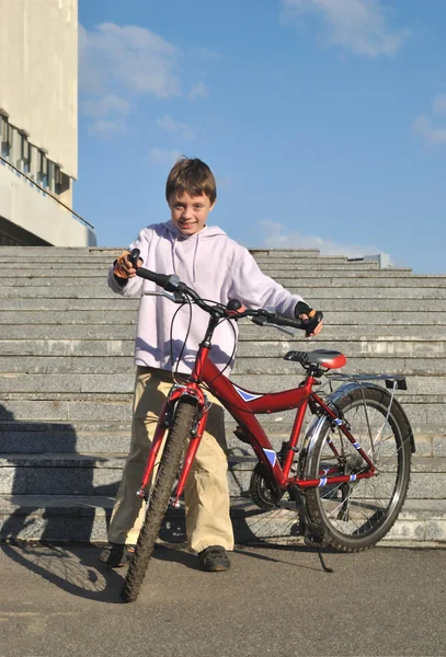 Le garçon se tient au vélo — Photo