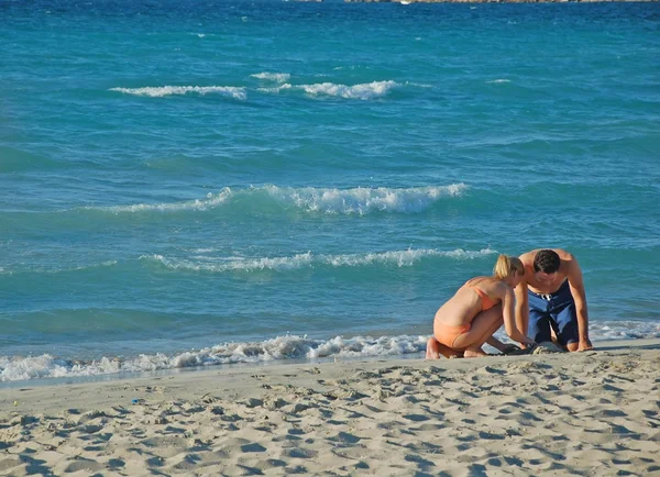 Unga par på stranden. — Stockfoto