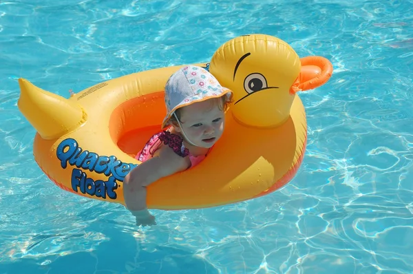 Детский утенок плавает в бассейне с лодкой . — стоковое фото