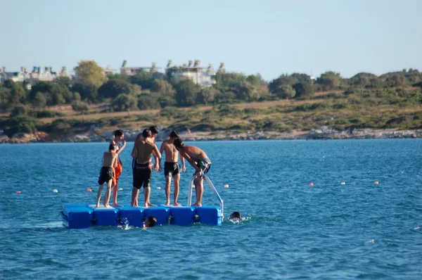 De jongens spelen in het midden van de zee. — Stockfoto