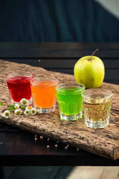 Färgglada uppsättning alkoholhaltiga drinkar i shotglas skyttar på träbord för en alkoholhaltig fest — Stockfoto
