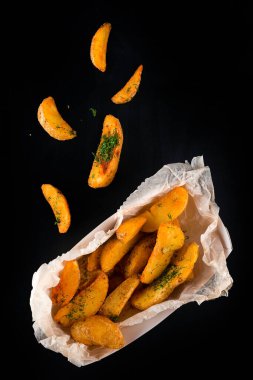 Siyah arka planda fırında patates kamışı, götürmek için patates kızartması. Patates kızartması.