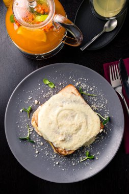 Jambon ve yumurtalı kızarmış baget dilimi Hollanda sosu altında Benedict, jambon ve peynir soslu Hollanda sandviçi.