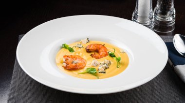 Karidesli sarı kremalı çorba. Sonbahar yemeği balkabağı çorbası ve karides. Yemekte servis edildi.