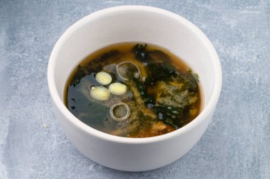 Japon miso çorbası. Masada tofu var. Gri arka planda seramik kasede. Tofulu Asya miso çorbası.