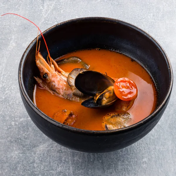 Thai soup Tom Yam with langoustine, classic tom yam with langoustines traditional thai spicy soup with Kaffir lime, langoustines and prawns, mussels