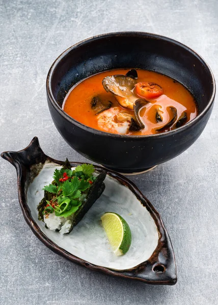 Thai soup Tom Yam with langoustine, classic tom yam with langoustines traditional thai spicy soup with Kaffir lime, langoustines and prawns, mussels