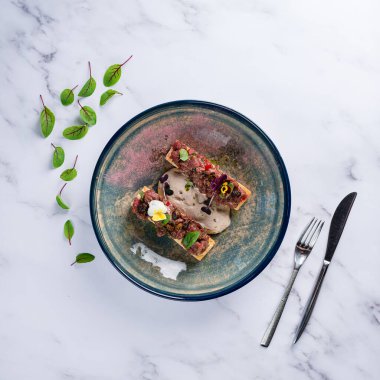Biftek tartartlı bruschetta, Biftek Tartare ve Roket ile Crostini, arka planda hafif bir görünüm üzerine kopyalama alanı, düz yatış