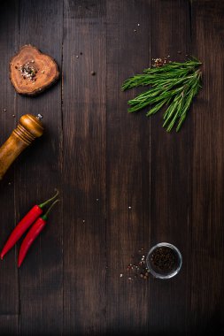 Biberiye ve biberiyeli boş ahşap masa arkaplanı, ahşap masada bitkiler ve baharatlar. Yemek pişirme ya da yemek geçmişi. Metin için boşluk. Kopyalama alanı olan yemek pişirme arka planı