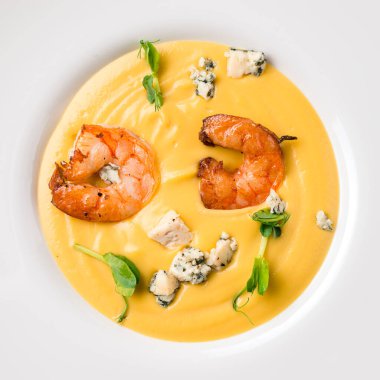 Karidesli sarı kremalı çorba. Sonbahar yemeği balkabağı çorbası ve karides. Akşam yemeği için sunulan üst görünüm, düz yatış