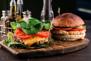 Salata yapraklı hamburger, ekmek ve klasik burger az karbonhidratlı keto burger, domates, peynir ve otla kaplı yaprak olmadan. Keto diyeti, keto burger tarifi, organik yiyecekler.