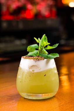 Kivili soğuk yaz limonatası, nane ve çikolata parçacıkları, kivili kokteyl ve ahşap arka planda bir bardakta nane şekeri. Kivili buzlu yeşil çay, alkolsüz moktail.