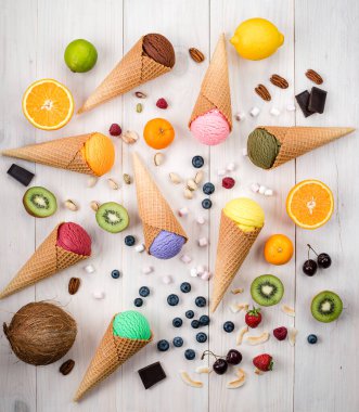 Beyaz masa manzaralı renkli dondurma külahı, külahlı farklı aromalı dondurmalar. Bir sürü dondurma kepçesi. Farklı tatlarda renkli dondurma kepçeleri.