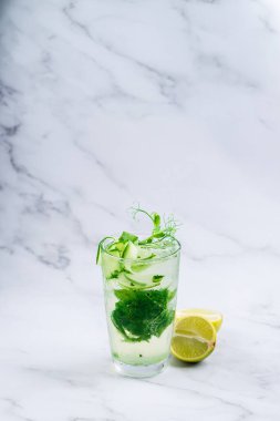 Salatalık, nane ve kireçle taze su, yaz içeceği sağlıklı içecek ve detoks konsepti. Sağlık hizmeti, fitness, sağlıklı beslenme diyeti konsepti. Salatalık, nane, kireç ve bezelye filizli soğuk detoks içeceği.