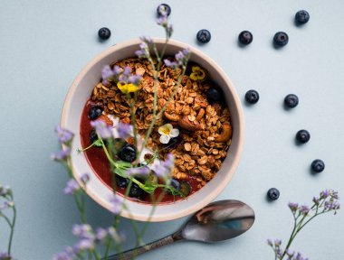 Yoğurtlu granola, badem ve taze yaban mersini. Müsli sağlıklı kahvaltı yulaf lapası taze yaban mersini, badem ve yoğurt tabakta, düz yerde yatıyordu.