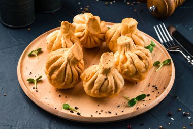 Tahta tepside etli Gürcistan usulü kızarmış Khinkali köftesi.