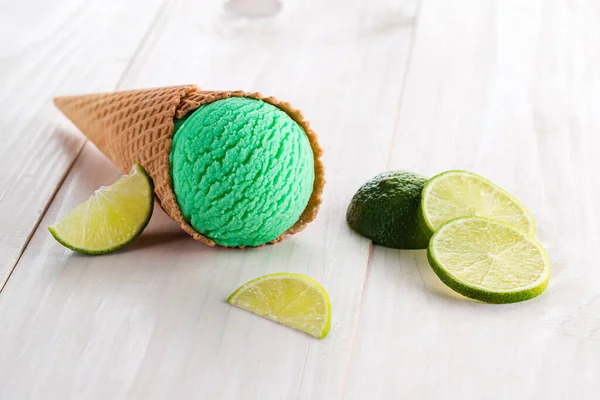 สกูปของไอศกรีมมะนาวสีเขียวสดในโคน — ภาพถ่ายสต็อก