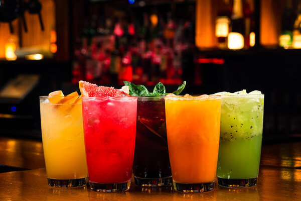 a set of summer multi-colored lemonades with cherry, basil, kiwi, sea buckthorn, raspberry and peach. Red, yellow, green and orange cocktail