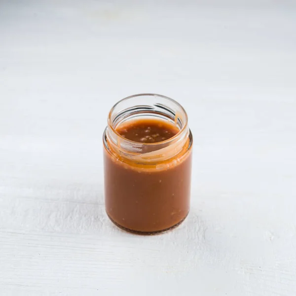 Domácí solený karamel ve skleněné nádobě. solený karamel ve sklenici — Stock fotografie