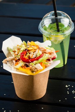 Karton bir kutuda tavuk ve sebzeli Çin eriştesi, Asya yemeği teslimatı, sokak yemeği kavramı, kraft kutusunda tava eriştesi.