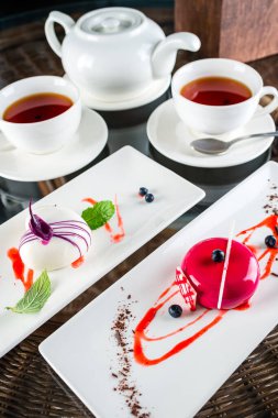 Kremalı pasta, Fransız tatlısı, çay, iki küçük top şeklinde kek, köpük kubbesi çay bardağında servis edilir.