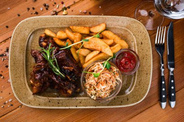 Fast food, ızgara kaburga ve patates dilimleri. Amerikan usulü ızgara pirzola ve kızarmış patates Amerikan yemeği.