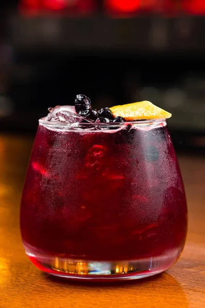 red cocktail with fresh berries and lemon slice. Fresh red water with lemon and blueberries. Exotic summer drink with citrus slices. Red berry or fruit lemonade