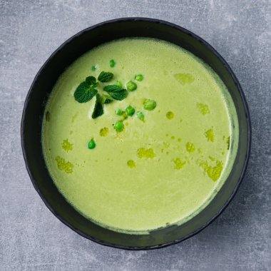 Yeşil bezelyeli krema çorbası, gri beton arka planda naneli taze bezelye çorbası. Vegan Bezelye Çorbası