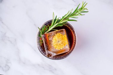 Hafif arka planda buzlu alkollü kokteyl negroni, biberiyeyle süslenmiş buzlu Negroni kokteyli.