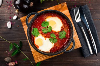 Shakshuka, dökme demir tepside. Orta doğu usulü yumurta domates ve biber soslu maydanozlu, Shakshuka yumurtalı kahvaltı..