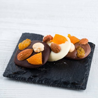 Fındıklı çikolatalı tatlı, badem, kurutulmuş kayısı ve kuru üzüm, ev yapımı çikolataya yakın çekim.