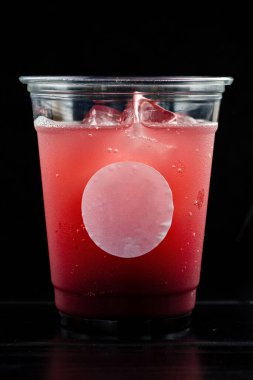 Kırmızı içki kokteyli ya da buzlu limonata. Teslimat konsepti