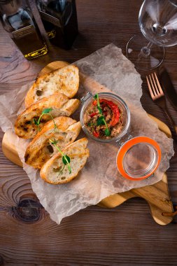 Tütsülenmiş ton balığı ve yumuşak peynir, krema, ahşap bir arka planda kavanozda ezme.