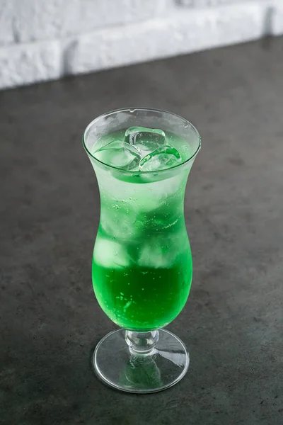 氷とシロップ入りのグリーンレモネード ガラスのソーダ水付きのグリーンフルーツ風味ドリンク — ストック写真