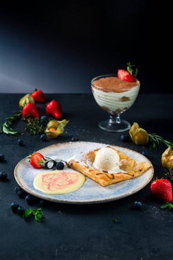 Bir kepçe dondurma ve taze böğürtlenli sıcak elmalı turta, bir restoranda servis edilen çilekli dondurmalı elmalı turta.