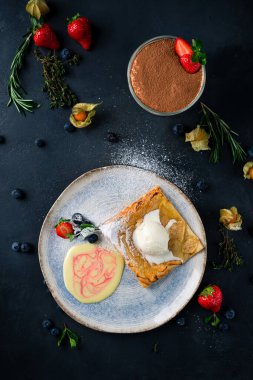 Bir kepçe dondurma ve taze böğürtlenli sıcak elmalı turta, bir restoranda servis edilen çilekli dondurmalı elmalı turta.