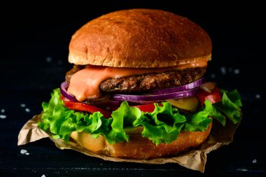sığır burger, hamburger, koyu ahşap arka planda tek bir taze klasik burger.