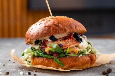 Pastırmalı hamburger, et, ahşap arka planda. Roka soslu pastırmalı burger, büyük boy sandviç.