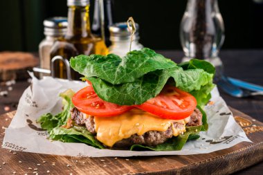 Marul yapraklı hamburger, az karbonhidratlı keto burger. Ekmeksiz, domatesli, peynirli ve otsuz. Keto diyeti, keto burger tarifi, organik yiyecekler.