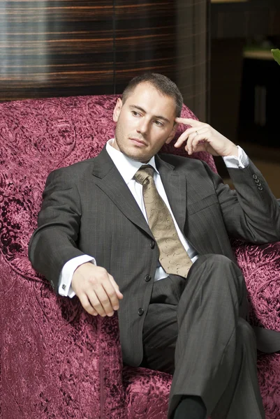 Businessman thinking on the chair in hotel lobby — Stock Photo, Image