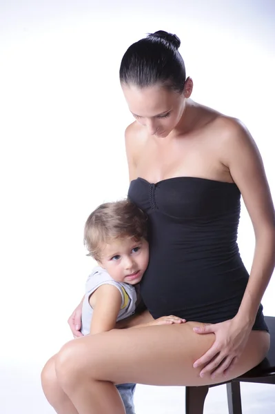 Embarazada mamá con el niño mayor sobre fondo blanco — Foto de Stock