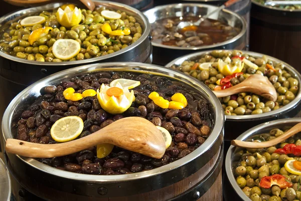 Range of different kinds olives arranged in wooden barrels — Stok fotoğraf