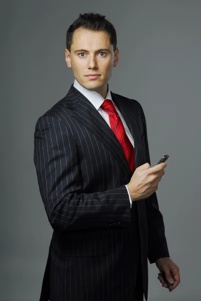 Picture of yang confident man dressed in business suit with cell phone in the hand — Stock Photo, Image