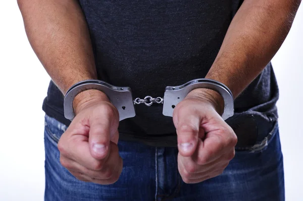 Человек в джинсах с наручниками сзади — стоковое фото