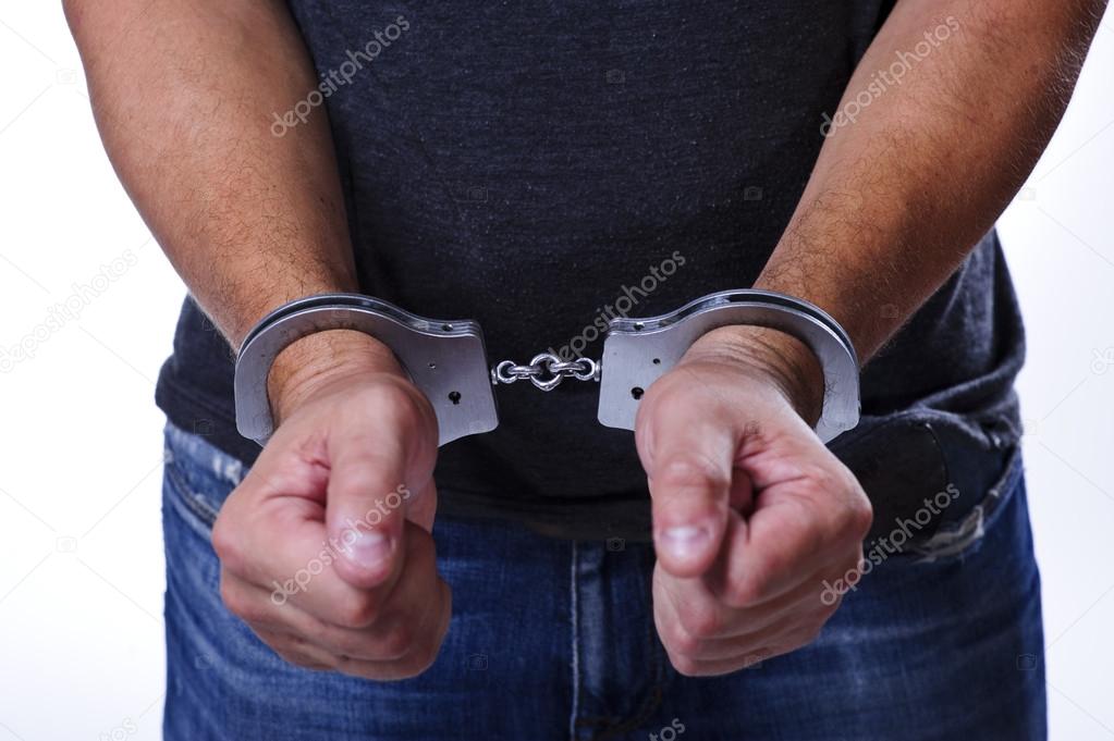 Man in jeans with handcuffs behind