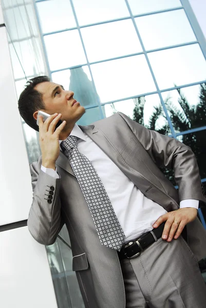 Yang and confident yang businessman stands next to the building wall — Stock Photo, Image